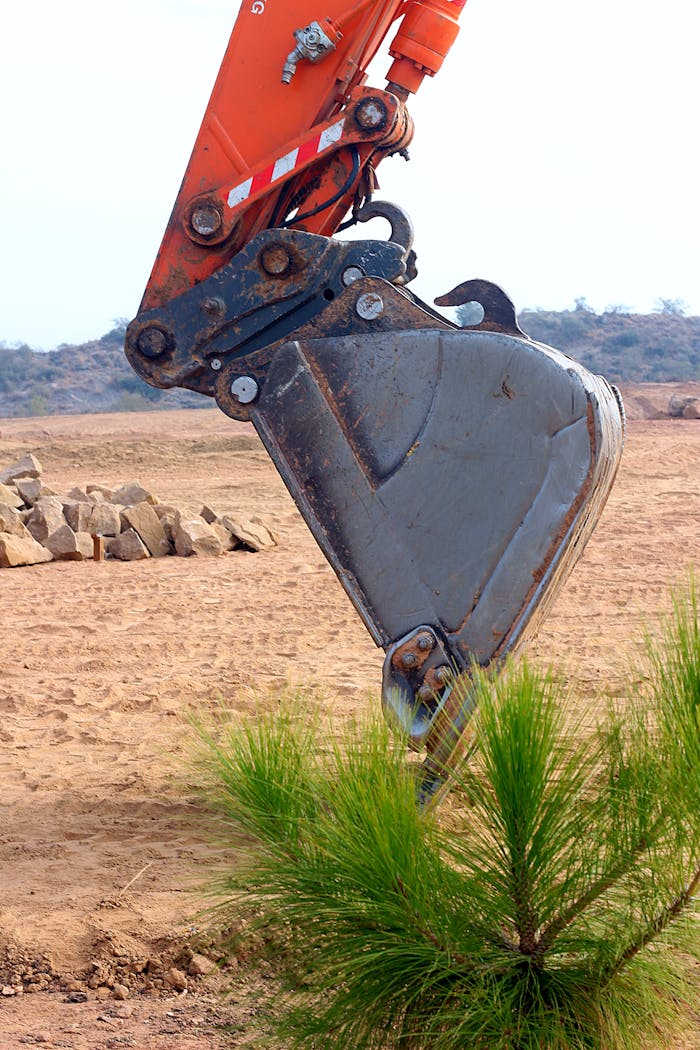 Services Close-up of an excavator arm digging in a sandy area in Punjab, Pakistan.